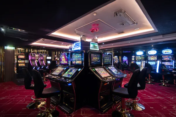 A woman in a luxurious green gown next to an ornate roulette wheel, capturing the upscale casino mood of KK333BD.